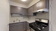 Located at 2414 Timbertrail Dr S in Columbus, Ohio, this two-story home offers a thoughtfully designed layout spread across two levels. The kitchen is a standout feature, showcasing gray shaker-style cabinetry that extends to the ceiling for generous storage capacity. Granite countertops with warm speckled tones provide ample prep space, while a classic tile backsplash in a grid pattern adds a clean, timeless aesthetic. The kitchen is equipped with a gas range and a stainless steel under-cabinet range hood, making it a functional space for cooking. A stainless steel sink with a chrome faucet is neatly integrated into the counter, completing the kitchen's practical design. The textured ceiling adds a subtle architectural detail throughout. The two-floor layout offers versatile living arrangements, with spaces across both levels providing room for comfortable everyday living. The overall aesthetic of the home blends practicality with understated style, featuring neutral tones and quality finishes that create a welcoming and functional environment throughout.