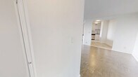Located at 301 Dixon Road in Toronto, this well-laid-out 2-bedroom, 1-bathroom unit offers a comfortable and functional living space across a single floor. The open living room is generously proportioned, featuring classic parquet flooring throughout and large floor-to-ceiling windows that flood the space with natural light and provide views of the surrounding greenery. A baseboard heating system runs along the windowed walls, ensuring year-round comfort. An entry hallway leads into the main living area, which connects seamlessly to the kitchen. The kitchen has been updated with white cabinetry, a subway tile backsplash, light tile flooring, and stainless steel appliances including a full-size refrigerator and dishwasher. The primary bedroom is a well-sized retreat with parquet flooring, mirrored sliding closet doors, and bright white walls. A dedicated walk-in closet with built-in shelving and hanging rods provides additional storage. The second bedroom also features parquet flooring and a mirrored closet. The bathroom is finished with classic white subway tile surrounding a full soaker tub and shower, complemented by chrome fixtures for a clean, timeless look. Throughout the unit, crisp white walls and consistent flooring create a cohesive, bright atmosphere.