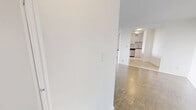 Located at 301 Dixon Road in Toronto, this well-laid-out 2-bedroom, 1-bathroom unit offers a comfortable and functional living space across a single floor. The open living room is generously proportioned, featuring classic parquet flooring throughout and large floor-to-ceiling windows that flood the space with natural light and provide views of the surrounding greenery. A baseboard heating system runs along the windowed walls, ensuring year-round comfort. An entry hallway leads into the main living area, which connects seamlessly to the kitchen. The kitchen has been updated with white cabinetry, a subway tile backsplash, light tile flooring, and stainless steel appliances including a full-size refrigerator and dishwasher. The primary bedroom is a well-sized retreat with parquet flooring, mirrored sliding closet doors, and bright white walls. A dedicated walk-in closet with built-in shelving and hanging rods provides additional storage. The second bedroom also features parquet flooring and a mirrored closet. The bathroom is finished with classic white subway tile surrounding a full soaker tub and shower, complemented by chrome fixtures for a clean, timeless look. Throughout the unit, crisp white walls and consistent flooring create a cohesive, bright atmosphere.