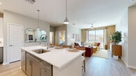 Located at 123 E Corporate Pl in Chandler, Arizona, this single-floor, 2-bedroom, 2-bathroom residence offers a thoughtfully designed open-concept layout with modern finishes throughout. The combined kitchen and living area serves as the heart of the home, where a large quartz-topped island with bar seating anchors the kitchen. Two-tone cabinetry, stainless steel appliances, pendant lighting, and light wood-style flooring complete the contemporary kitchen design. The living room flows seamlessly from the kitchen and is bathed in natural light from a large sliding glass door that opens to a view of a resort-style pool — an ideal setting for relaxing or entertaining. Each bedroom features plush carpet, ceiling fans, and windows that allow ample natural light. The primary bedroom includes a dedicated walk-in closet with built-in shelving. Both bathrooms are finished with gray cabinetry, white quartz countertops, under-mount sinks, and backlit vanity mirrors, with light wood-style flooring tying the look together. Each bathroom conveniently connects to its own closet. The overall ambiance of this residence is warm and inviting, with a neutral color palette, clean lines, and quality finishes that create a comfortable and functional living environment.