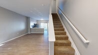 Located at 5730 Silver Falls St in Dublin, OH, this two-story home offers 2 bedrooms, 3 bathrooms, and a thoughtfully organized layout spread evenly across two floors. The main level features an open-concept living and kitchen area with light wood-style flooring throughout. The kitchen is well-appointed with white shaker cabinetry, subway tile backsplash, stainless steel appliances including a refrigerator, range, and microwave, and a breakfast bar. A sliding glass door floods the space with natural light and provides outdoor access. A half bathroom is conveniently located on the main floor. Carpeted stairs with a white railing lead to the upper level, where two bedrooms and two full bathrooms are found. The spacious primary bedroom features plush carpeting and dual windows that allow abundant natural light and neighborhood views. The second bedroom also features wood-style flooring and a bright window. Both upper-level bathrooms are clean and functional, with one offering a sliding glass shower enclosure and a single vanity. A dedicated laundry area with washer and dryer hookups and overhead shelving adds everyday convenience. Neutral gray walls and clean white trim unify the home's modern, understated aesthetic throughout.
