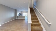 Located at 5730 Silver Falls St in Dublin, OH, this two-story home offers 2 bedrooms, 3 bathrooms, and a thoughtfully organized layout spread evenly across two floors. The main level features an open-concept living and kitchen area with light wood-style flooring throughout. The kitchen is well-appointed with white shaker cabinetry, subway tile backsplash, stainless steel appliances including a refrigerator, range, and microwave, and a breakfast bar. A sliding glass door floods the space with natural light and provides outdoor access. A half bathroom is conveniently located on the main floor. Carpeted stairs with a white railing lead to the upper level, where two bedrooms and two full bathrooms are found. The spacious primary bedroom features plush carpeting and dual windows that allow abundant natural light and neighborhood views. The second bedroom also features wood-style flooring and a bright window. Both upper-level bathrooms are clean and functional, with one offering a sliding glass shower enclosure and a single vanity. A dedicated laundry area with washer and dryer hookups and overhead shelving adds everyday convenience. Neutral gray walls and clean white trim unify the home's modern, understated aesthetic throughout.