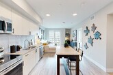 Located at 201 North La Brea Avenue in Inglewood, CA, this thoughtfully designed one-bedroom, one-bathroom residence offers a bright and modern living experience. The open-concept kitchen and living area form the heart of the unit, where sleek white cabinetry, a striking marble-style tile backsplash, and a full suite of stainless steel appliances — including a refrigerator, range, microwave, and dishwasher — create a polished and functional kitchen. Light wood-tone flooring flows throughout, complementing the clean, neutral palette. A dining table positioned centrally between the kitchen and living area provides a natural transition between spaces. The living room is bathed in natural light from floor-to-ceiling sliding glass doors that open to a private balcony overlooking the surrounding neighborhood. The bedroom offers a tranquil retreat with windows framing outdoor views, generous proportions, and a dedicated closet for ample storage. The bathroom features a full soaking tub and shower combination with clean white tile surround and wood-tone flooring that ties seamlessly to the rest of the unit. Recessed lighting throughout maintains a bright, contemporary ambiance, making this a well-appointed urban residence in a convenient Inglewood location.