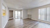 Located at 11025 S 51st St in Phoenix, AZ, this single-story 2-bedroom, 2-bathroom home offers a clean, modern aesthetic throughout. Wood-style plank flooring runs consistently across the living areas and bedrooms, complemented by neutral gray walls and crisp white trim, creating a bright and cohesive feel.

The open living room provides a comfortable gathering space with built-in shelving, a textured ceiling, and sliding glass doors that open to a private balcony. The kitchen is outfitted with white shaker-style cabinetry, white countertops, a double-basin sink, and stainless steel appliances including a range, microwave, and dishwasher.

Both bedrooms are generously proportioned, with the primary bedroom featuring a ceiling fan and direct access to a spacious walk-in closet with built-in shelving and hanging rods. The second bedroom also benefits from built-in shelving, adding practical storage. Two full bathrooms serve the home — one with a tub/shower combo and white cabinetry, and another with a single-sink vanity. An in-unit laundry area adds everyday convenience. The layout is practical and well-organized, making efficient use of the available space throughout.