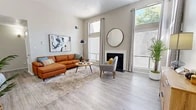 Located in Albuquerque, NM, this well-appointed 3-bedroom, 2-bathroom single-story home offers a thoughtfully designed layout across a comfortable footprint. The bright living room is a standout feature, boasting soaring ceilings, large windows that flood the space with natural light and views of surrounding greenery, light wood-look flooring, and a classic fireplace — creating a warm and inviting atmosphere. Adjacent to the living room, the dining area provides an intimate setting with continued access to natural light through nearby windows. The kitchen is outfitted with white shaker cabinetry, a white quartz countertop island with bar seating, stainless steel appliances, and light wood-look flooring, offering both style and functionality. The generously sized primary bedroom features plush carpeting and an expansive dual sliding-door closet, providing ample storage. Additional bedrooms are well-sized with dedicated closet space, including a walk-in closet. The bathrooms are clean and functional, featuring a walk-in shower with grab bars. A dedicated laundry room with a full-size washer and dryer adds everyday convenience. Neutral tones throughout create a cohesive and move-in-ready feel.