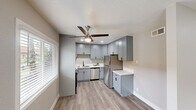 Located at 3730 Southview Dr in San Diego, CA, this 2-bedroom, 1-bathroom residence offers a thoughtfully updated interior with a cohesive, modern aesthetic. The combined kitchen and living room area serves as the heart of the home, featuring stylish gray shaker-style cabinetry extending to the ceiling, white quartz countertops, a stainless steel sink with a matte black faucet, and stainless steel appliances including a refrigerator and dishwasher. Light wood-look flooring and a ceiling fan with an integrated light complete the space, while a window with horizontal blinds invites natural light. The living area provides a comfortable, open feel with recessed lighting and direct access to the front entry. Both bedrooms are finished with plush carpeting and neutral-toned walls, with the primary bedroom offering a ceiling fan, a window with outdoor views, and ample room. The second bedroom is bright and versatile. The full bathroom is clean and modern, featuring a white vanity with black hardware, a tub/shower combination, and light wood-look flooring. A hallway connects the rooms efficiently. The overall ambiance is fresh, functional, and move-in ready.