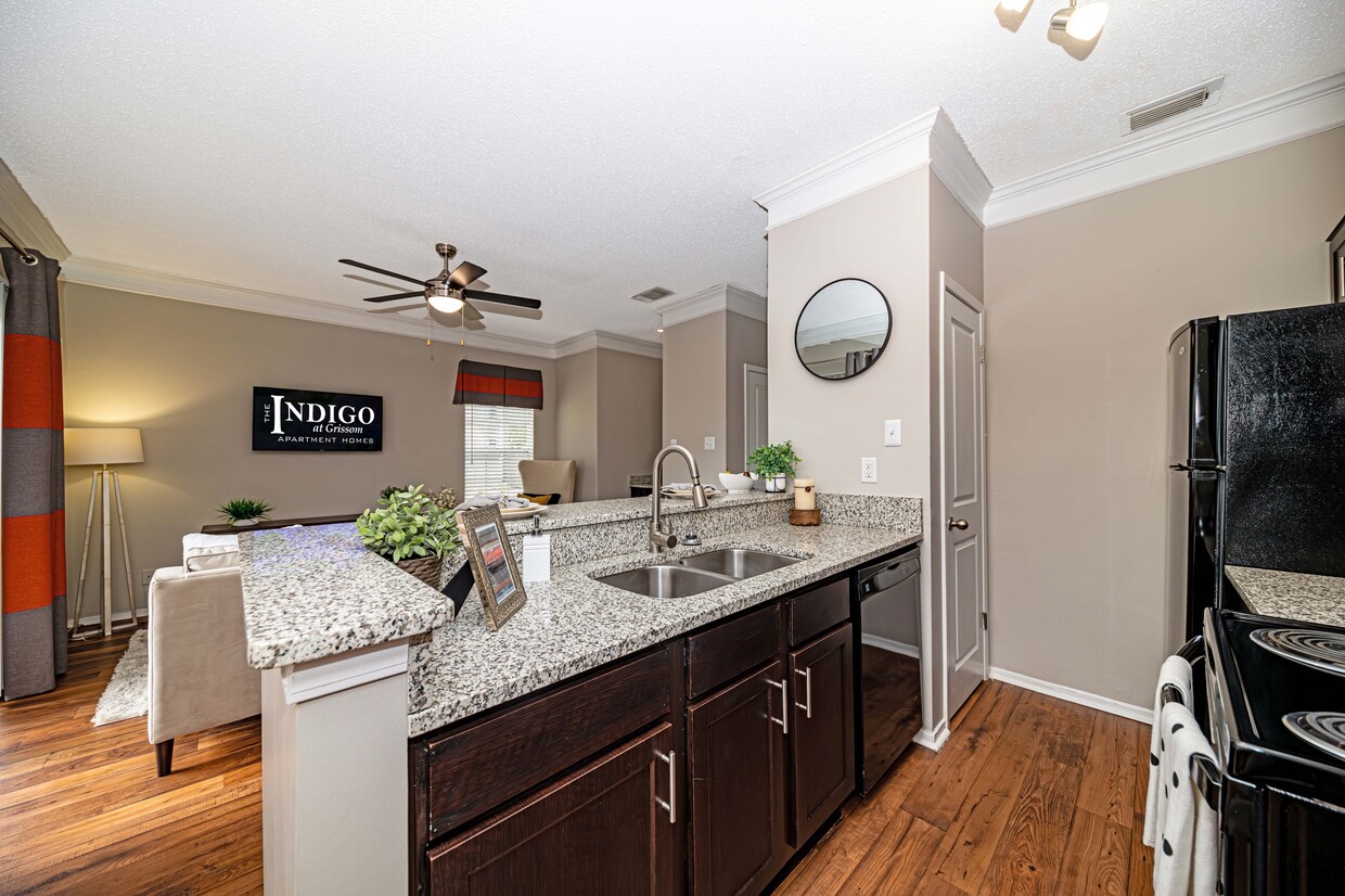 Kitchen with granite counters and black appliances - The Indigo at Grissom