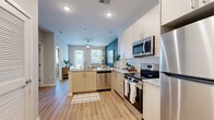 Located at 235 McDonough Rd in McDonough, GA, this one-bedroom, one-bathroom residence offers a thoughtfully designed layout across a single floor. The open-concept kitchen and living area serves as the heart of the home, where white cabinetry, granite countertops, and a full suite of stainless steel appliances — including a refrigerator, range, microwave, and dishwasher — create a functional and stylish cooking space. A peninsula with bar seating provides a seamless transition into the living area, which is highlighted by a bold teal accent wall, light wood-style flooring, and large windows with a glass door that invites abundant natural light and outdoor views. The bedroom is a calm retreat featuring a window with exterior views, warm neutral tones, and direct access to a spacious walk-in closet with wire shelving systems offering ample storage. The bathroom is well-appointed with granite countertops, taupe cabinetry, a large vanity mirror, and a tiled walk-in shower. The entry foyer provides a clean, welcoming arrival with louvered storage doors and easy access to the kitchen. Light wood-style flooring flows consistently throughout, tying the entire space together in a cohesive, modern aesthetic.