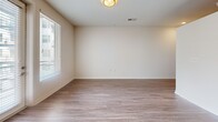 This one-bedroom, one-bathroom apartment at 2700 E College Ave in Decatur, Georgia offers a well-designed layout across a single floor. The open-concept living, dining, and kitchen area serves as the heart of the unit, featuring wood-style plank flooring, recessed lighting, and a large window that invites natural light. The kitchen is appointed with light wood cabinetry, a decorative tile backsplash, stainless steel appliances including a refrigerator, range, microwave, and dishwasher, and a single-basin sink. A bright hallway with a sliding closet door connects the main living area to the private quarters. The bedroom offers plush carpeting, high ceilings, and two double-door closets providing generous storage. The bathroom is finished with large-format tile flooring, a vanity with wood-toned cabinetry, a tub-shower combination, and a conveniently integrated stacked washer and dryer unit. Additional features include a private patio for outdoor enjoyment and a dedicated laundry area. The unit's clean white walls, consistent finishes, and thoughtful layout create a modern and functional living environment in the heart of Decatur.