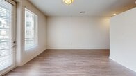 This one-bedroom, one-bathroom apartment at 2700 E College Ave in Decatur, Georgia offers a well-designed layout across a single floor. The open-concept living, dining, and kitchen area serves as the heart of the unit, featuring wood-style plank flooring, recessed lighting, and a large window that invites natural light. The kitchen is appointed with light wood cabinetry, a decorative tile backsplash, stainless steel appliances including a refrigerator, range, microwave, and dishwasher, and a single-basin sink. A bright hallway with a sliding closet door connects the main living area to the private quarters. The bedroom offers plush carpeting, high ceilings, and two double-door closets providing generous storage. The bathroom is finished with large-format tile flooring, a vanity with wood-toned cabinetry, a tub-shower combination, and a conveniently integrated stacked washer and dryer unit. Additional features include a private patio for outdoor enjoyment and a dedicated laundry area. The unit's clean white walls, consistent finishes, and thoughtful layout create a modern and functional living environment in the heart of Decatur.
