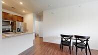 This single-floor unit offers a thoughtfully designed layout that balances functionality and comfort throughout its key living areas. Rich wood-look flooring runs continuously through every room, providing a warm and cohesive aesthetic.

The kitchen serves as a central highlight, featuring a peninsula with granite countertops and a double-basin sink, complemented by stainless steel appliances including a refrigerator with ice maker, an electric range, and a built-in microwave. Rich cabinetry with glass-front upper panels provides ample storage and visual depth.

The living area is bright and welcoming, benefiting from natural light through a window fitted with blinds. A ceiling fan adds comfort, while clean white walls create a neutral backdrop suitable for a variety of décor styles.

The bedroom continues the same warm flooring and features a ceiling fan, a window with outdoor views, and a two-panel interior door that adds a clean architectural touch. The full bathroom is neatly appointed with a granite-topped vanity, dark wood cabinetry, a wall mirror, and a shower-tub combination.

Additional utility space accommodates a water heater, completing the practical amenities of this well-maintained and move-in ready unit.