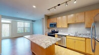 Located in Circle Pines, MN, this well-appointed 3-bedroom, 2-bathroom residence offers a thoughtfully designed single-level layout. The kitchen is a standout feature, showcasing light maple cabinetry, granite countertops, a full suite of stainless steel appliances including a range, microwave, dishwasher, and refrigerator, and a generous center island with additional seating space. Track lighting and hardwood-style flooring add a polished feel to this central gathering area. The spacious primary bedroom is bathed in natural light through a large window with outdoor views of the surrounding greenery, and features plush carpeting. It connects to a dedicated full bathroom and a walk-in closet outfitted with wire shelving and hanging rods for ample storage. Two additional carpeted bedrooms each offer closet space and natural light from wide windows. The second full bathroom features a shower/tub combo, warm wood-tone cabinetry, and hardwood-style flooring, mirroring the finishes of the primary bath. The clean, neutral color palette throughout the home creates a bright and welcoming ambiance, making this a functional and comfortable residence suited for a variety of lifestyles.