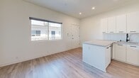 Located on Pico Boulevard in Santa Monica, California, this single-story one-bedroom, one-bathroom unit offers a thoughtfully designed layout that maximizes its compact footprint. Throughout the space, light gray wood-look flooring provides a cohesive, contemporary foundation, complemented by crisp white walls that enhance the sense of brightness and openness.

The living and dining area occupies the main open zone, benefiting from a large window that invites natural light and offers a view of the surrounding neighborhood. Recessed lighting supplements daylight, and the space flows directly into the kitchen, which features white flat-front cabinetry with matte black hardware, a white subway tile backsplash, light countertops, and stainless steel appliances including a gas range, over-the-range microwave, and refrigerator. A peninsula provides additional counter space and visual separation between the kitchen and living area.

The bedroom is a well-proportioned private retreat with a ceiling fan, a horizontal window allowing natural light, and a mirrored sliding-door closet that adds depth to the room. The bathroom is finished in a modern style with large-format white wall tiles surrounding a bathtub and shower, a wall-mounted vanity with a white basin, matte black fixtures, and a framed mirror. This unit presents a clean, functional design well-suited to Santa Monica living.