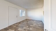 Located at 5755 E River Rd in Tucson, Arizona, this single-floor studio unit offers a practical and well-organized layout across a compact footprint. Wood-look plank flooring runs consistently throughout the space, lending a cohesive and modern feel to every room.

The open living area is bright and airy, with white walls, a textured ceiling, and a ceiling fan providing both comfort and airflow. Multiple windows allow natural light to fill the space, with views of the surrounding exterior. A dedicated entry door leads directly into the living area, which connects seamlessly to the kitchen via a pass-through window and open layout.

The galley-style kitchen is efficiently designed, featuring warm natural wood cabinetry on both sides, dark granite-style countertops, a stainless steel sink, and black appliances including a refrigerator, range, and dishwasher. A pendant light with a brass fixture hangs at the kitchen's edge, adding a warm accent. Upper and lower cabinets maximize storage throughout the kitchen corridor.

The bathroom is clean and functional, featuring a full soaking tub with a shower overhead, set against smooth, neutral-toned wall surround panels. Dark countertop surfaces complement the overall design palette.

A closet provides dedicated storage, completing this efficiently planned single-level unit in the heart of Tucson.