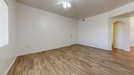 Located at 13621 W Glendale Ave in Glendale, Arizona, this single-floor home offers two bedrooms and two full bathrooms within a well-organized layout. Wood-look plank flooring runs consistently throughout the space, providing a cohesive and easy-to-maintain finish across every room.

The kitchen is equipped with light wood cabinetry, a white electric range, black refrigerator, dishwasher, and a sink with ample counter space. A pendant light fixture adds a functional accent above the open kitchen area.

The spacious primary bedroom features a ceiling fan with light, vertical blind-covered windows that allow natural light, and direct access to an en-suite bathroom. The en-suite includes a walk-in shower with glass sliding doors, a wood-toned vanity with a white countertop, and wood-look flooring. The primary bedroom also provides access to a walk-in closet.

The second bedroom is comparably sized, also featuring a ceiling fan, natural light from a window with vertical blinds, and a built-in sliding-door closet. The second full bathroom includes a bathtub/shower combination, a matching wood-toned vanity, and consistent flooring.

The living room is open and bright, with a ceiling fan and a door providing additional access. Two hallways connect the rooms efficiently, completing this practical and neatly designed single-level home.