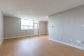 Located at 1577 Lawrence Ave W in Toronto's Lawrence Heights neighbourhood, this 2-bedroom, 1-bathroom unit offers a clean, modern interior with a bright and functional layout. Light hardwood-style flooring runs throughout the unit, complementing the neutral grey-white walls and white baseboards for a cohesive, contemporary aesthetic.

The living room is a generously sized open area bathed in natural light from a large window overlooking the surrounding neighbourhood. The galley-style kitchen is efficiently designed, featuring white upper and lower cabinetry, a stainless steel refrigerator, an electric range, and a stainless steel sink with a sleek countertop — all arranged along parallel walls to maximize workflow.

The primary bedroom is a well-proportioned space with its own natural light source via a large window, while the second bedroom also benefits from a window and an open, flexible layout. A dedicated closet room provides ample built-in hanging storage, a practical addition that enhances day-to-day organization.

The bathroom is clean and straightforward, outfitted with a full soaker tub and shower combination set against white subway tile. The overall unit presents a move-in-ready, freshly maintained condition with a bright, uncluttered atmosphere throughout.