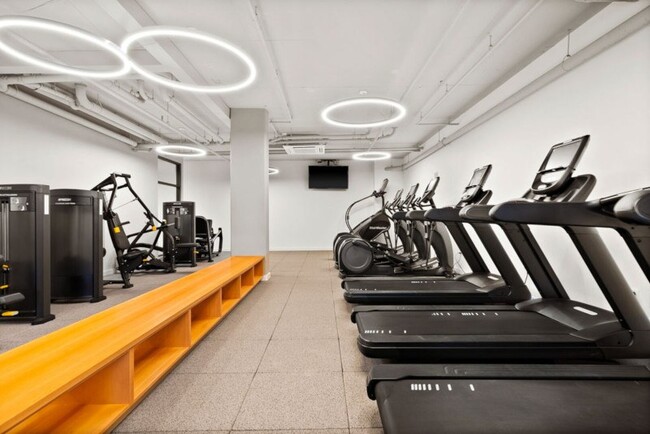 Gimnasio con equipo cardiovascular y pesas - EdgePoint Apartments