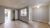 Located at 7100 Hooker St in Westminster, Colorado, this 2-bedroom, 1-bathroom unit offers a practical and well-organized single-floor layout. The living room serves as the central gathering space, featuring wood-look vinyl plank flooring, neutral gray walls, a textured ceiling, and a window that brings in natural light along with views of the surrounding area. A wall-mounted air conditioning unit and baseboard heating ensure year-round comfort. A distinctive pass-through window connects the living area to the kitchen, which is finished with white cabinetry, a white refrigerator, and a clean, functional design. The primary bedroom is a well-proportioned room with its own closet storage, while the second bedroom also features wood-look flooring, a window with outdoor views, and baseboard heating. Both bedrooms benefit from dedicated closet space, including sliding-door and built-in shelving options. The bathroom includes a full tub and shower combination with floor-to-ceiling warm-toned tile surround, a window for natural ventilation, and wood-look flooring. Textured ceilings are consistent throughout the unit, and crisp white trim and baseboards provide a clean finish across every room.
