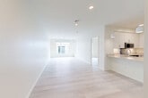 Located at 46 Soldiers Field Place in Boston, MA, this well-designed one-bedroom, one-bathroom residence offers a thoughtfully organized layout across a single floor. The open-concept living, dining, and kitchen area forms the heart of the home, bathed in natural light from large windows and enhanced by light-toned hardwood flooring that runs throughout the space. Crisp white walls and recessed lighting contribute to a bright, airy ambiance.

The kitchen is outfitted with white shaker-style cabinetry, quartz countertops, stainless steel appliances including an electric range, over-range microwave, and a stainless sink — all complemented by a breakfast bar that connects seamlessly to the dining and living areas. A pantry provides additional storage.

The bedroom is a calm, well-proportioned retreat featuring large windows that allow generous natural light and views of the surrounding neighborhood. Two closets offer practical storage solutions throughout the residence.

The bathroom features dark slate-style tile flooring, a vanity with grey cabinetry, a framed mirror, and overhead lighting, striking a clean contrast to the home's otherwise light palette. An in-unit laundry area adds everyday convenience, rounding out this functional and modern Boston residence.