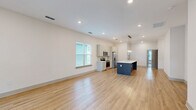 Located at 5000 Seaforth St in Shallotte, NC, this single-story home offers a thoughtfully designed floor plan with 3 bedrooms, 2 bathrooms, and 4 closets. The open-concept kitchen and living area serves as the heart of the home, featuring light hardwood-style flooring, recessed lighting, and a striking kitchen island with a bold navy-blue base and crisp white countertop. The kitchen is equipped with stainless steel appliances, soft gray cabinetry, and stylish pendant lighting suspended from a brass fixture above the island. The living area is bright and spacious, with large windows allowing generous natural light to fill the room. The front entry opens to a welcoming living space with two side-by-side windows framing views of the surrounding greenery. Bedrooms are finished with plush carpeting and individual windows providing natural light and neighborhood views. The bathrooms feature wood-look tile flooring and a glass-enclosed walk-in shower. A dedicated laundry room accommodates a full-size washer and dryer with overhead shelving. Externally, the home showcases charming blue horizontal siding, a manicured lawn, and a concrete walkway. Four closets provide ample storage throughout.