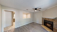 This single-story, 2-bedroom, 2-bathroom home in Fort Smith, Arkansas offers a practical and comfortable layout across a well-utilized floor plan. The living room is a standout space, featuring light wood-style flooring, a textured ceiling, a ceiling fan, and a striking stone-faced fireplace with a shiplap surround. A sliding glass door opens to a private balcony, filling the room with natural light and outdoor views. The kitchen connects openly to the living area via a pass-through window and is equipped with ample gray cabinetry, tile countertops, white appliances including a refrigerator, range, microwave, and dishwasher, and light tile flooring. A dedicated pantry provides additional storage. Both bedrooms feature wood-style flooring, ceiling fans with lighting, and natural light from windows with blinds. Closet space is plentiful, with three closets distributed throughout the home. The bathrooms include tile flooring and a tub-shower combination with tiled surround. A dedicated laundry room with overhead cabinetry and washer/dryer hookups adds everyday convenience. The home's neutral color palette and functional layout make it an accessible and move-in-ready space.