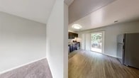 Located at 25 Pittston Circle in Owings Mills, MD, this two-story home offers a practical and well-organized layout across two floors. The main level houses the living and dining areas, where wood-look vinyl flooring flows through the open kitchen and into the living space. The kitchen is equipped with dark espresso cabinetry, light countertops, stainless steel appliances including a dishwasher, gas range, and refrigerator, as well as a stacked washer/dryer unit — maximizing functionality within a compact footprint. A sliding glass door in the adjoining area allows natural light to filter in and provides outdoor views. The carpeted living area connects seamlessly to the staircase leading to the upper floor. Upstairs, two bedrooms feature plush carpeting, neutral wall tones, and windows with blinds that bring in natural light and views of the surrounding greenery. The primary bedroom offers a comfortable, well-proportioned space. The full bathroom includes a tiled tub/shower combination with brushed gold fixtures. Throughout the home, clean lines, neutral finishes, and a straightforward layout create a bright, functional living environment well-suited for everyday comfort.