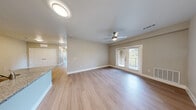 Located in Del Valle, TX, this single-story, 4-bedroom, 3-bathroom home offers a well-designed layout with modern finishes throughout. Light wood-style flooring flows consistently across all rooms, creating a clean and cohesive aesthetic.

The kitchen and living area form an open, functional hub at the heart of the home. The kitchen is equipped with stainless steel appliances — including a refrigerator, electric range, and microwave — complemented by dark espresso cabinetry, granite-style countertops, a subway tile backsplash, and a single-basin sink.

The spacious living room features a ceiling fan, neutral wall tones, and French doors that open to the outdoors, filling the space with natural light. Each of the four bedrooms includes a ceiling fan and a double-door closet, providing ample storage. Bedrooms benefit from natural light through windows with views of the surrounding greenery.

The three bathrooms are finished with clean, white subway tile walk-in showers enclosed by glass and brushed nickel hardware, maintaining a consistent and polished look. Light wood-style flooring extends into the bathrooms, tying the design together.

Overall, the home presents a fresh, move-in-ready interior with a neutral palette, modern fixtures, and practical layout suited for comfortable everyday living.