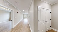Located at 1776 E Second St in Scotch Plains, NJ, this well-appointed one-bedroom, one-bathroom residence offers a thoughtfully designed layout across a single floor. Light-toned hardwood flooring flows consistently throughout, lending warmth and cohesion to the entire space.

The open-concept kitchen and living area serves as the heart of the unit. The kitchen features a large peninsula with a white quartz countertop and an integrated sink, white shaker-style cabinetry with matte black hardware, stainless steel appliances including a gas range, microwave, and refrigerator, and stylish pendant lighting overhead. The adjoining living area is bathed in natural light from oversized, grid-pane windows that frame views of the surrounding Scotch Plains neighborhood.

The spacious bedroom offers a bright, airy atmosphere with its own large window and generous natural light. It includes two closets — one of which is a well-organized walk-in with built-in shelving — providing ample storage. The full bathroom is finished with large-format marble-style tile flooring, a white vanity with quartz countertop, and clean, contemporary fixtures. Additional conveniences include a dedicated laundry area and crown molding details throughout the main living spaces, contributing to an overall polished and modern aesthetic.