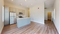 Located at 45 Diana Street in Memphis, Tennessee, this single-floor space offers a thoughtfully designed layout that maximizes every square foot. The open-concept living and kitchen area serves as the heart of the unit, featuring elevated ceilings, recessed lighting, and a ceiling fan that enhance the sense of airiness. Large windows and a glass door flood the space with natural light while offering views of the surrounding neighborhood. The kitchen is equipped with a central island complete with a sink and stainless steel dishwasher, complemented by gray cabinetry, a stainless steel refrigerator, microwave, and range with a subway tile backsplash and white countertops. Warm-toned wood-look flooring runs throughout, tying the spaces together cohesively. A dedicated bedroom area adjoins the living space, offering a clean, neutral palette. The hallway connects the main living areas to the private spaces, flanked by a closet with louvered doors and matte black hardware accents. The bathroom is finished with elegant marble-look tile in the walk-in glass-enclosed shower, complemented by hexagonal floor tile, a white vanity, and wood-look flooring. Clean lines, neutral tones, and modern fixtures define the overall aesthetic of this well-appointed Memphis residence.