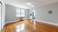 Located on Tichester Road in Toronto's desirable Forest Hill neighbourhood, this one-bedroom, one-bathroom unit offers a well-considered layout across a single floor. Warm-toned hardwood flooring flows throughout the main living areas, lending a timeless character to the space.

The living room is a standout, featuring a classic white decorative fireplace mantel, neutral grey walls, and a window that draws in natural light. A cast iron radiator adds to the period charm. The space connects openly to the kitchen, which has been updated with white shaker cabinetry, a subway tile backsplash, dark countertops, stainless steel appliances including a fridge and dishwasher, and glossy ceramic tile flooring. Large windows flood the kitchen with ample natural light and views of the surrounding greenery.

The bedroom is a comfortable, well-proportioned room with hardwood floors, a natural light-filled window, a radiator, and a generous sliding double-door closet alongside an additional single door for storage. The four-piece bathroom retains its classic character with hexagonal mosaic tile flooring, white subway tile wainscoting, a soaking tub, pedestal-style vanity with a large mirror, and dual windows providing bright, natural light. This unit thoughtfully blends classic architectural details with modern updates.