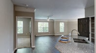 This well-appointed 2-bedroom, 2-bathroom single-floor residence at 4407 Hopson Rd in Durham, NC offers a thoughtfully designed layout with generous living space. The open-concept combined dining and living area is a centerpiece of the home, showcasing wide-plank hardwood-style flooring, crown molding, and abundant natural light streaming through multiple windows. A ceiling fan adds comfort, while French doors lead out to a private balcony with outdoor views. The kitchen is equipped with warm wood cabinetry, granite countertops, a subway tile backsplash, and stainless steel appliances, complemented by an adjacent pantry for added storage. Both bedrooms feature plush carpeting and ceiling fans, with the spacious primary bedroom offering generous proportions and direct access to a dual-vanity en-suite bathroom with granite countertops and a walk-in closet. The second bathroom mirrors the same quality finishes, including a granite-topped white vanity and a tub-shower combination. A dedicated laundry room with wire shelving, a utility room, and multiple closets throughout add to the home's practicality. Neutral tones and consistent finishes create a cohesive and inviting ambiance throughout the entire residence.
