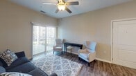 This single-story residence at 11101 Hyde Pointe Ct. in Charlotte, NC, offers a well-designed layout across multiple rooms with consistent, contemporary finishes throughout. The living area serves as the heart of the home, featuring wood-style flooring, a ceiling fan, and a sliding glass door dressed with vertical blinds that opens to a private balcony with neighborhood views, allowing natural light to fill the space.

The kitchen is appointed with rich dark cabinetry, granite countertops, stainless steel appliances including a refrigerator, range, and microwave, and a peninsula with pendant lighting overhead. The bar-height counter provides an informal dining option that connects seamlessly to the living area.

The bedrooms are carpeted and include ceiling fans and windows with horizontal blinds that bring in natural light. One room functions as a flexible space suitable for a home office or additional sleeping area. The bathrooms feature wood-style flooring, dark vanity cabinetry with granite countertops, and a full tub-shower combination. A dedicated in-unit laundry room with wire shelving and washer and dryer connections adds everyday convenience. Neutral wall tones throughout give the space a clean, cohesive aesthetic.