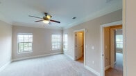 Located along Valley Vista Road in Knoxville, Tennessee, this single-story residence offers a thoughtfully designed layout with a neutral, warm color palette throughout. The living area features plush carpeting, crown molding, and a tray ceiling with a ceiling fan, while double doors with transom windows allow natural light to fill the space. An adjoining dining area, accented by a chandelier and chair-rail molding, connects seamlessly to the kitchen, which is outfitted with white shaker-style cabinetry extending to the ceiling, dark granite countertops, under-cabinet lighting, hardwood flooring, and stainless steel appliances including a range, microwave, and dishwasher. The primary bedroom includes crown molding, a ceiling fan, a walk-in closet, and direct access to an en-suite bathroom featuring granite countertops, white cabinetry, tile flooring, and a separate glass-enclosed shower. Additional bedrooms are generously sized with carpeted floors, ceiling fans, and ample closet space. A secondary bathroom offers a tiled tub-shower combination, granite vanity, and tile flooring. The overall ambiance is clean, bright, and move-in ready.