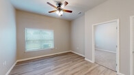 This single-floor residence offers a well-designed, open-concept layout that seamlessly connects the living and kitchen areas. The living space features light wood-look luxury vinyl plank flooring, warm neutral wall tones, and a ceiling fan with integrated lighting, creating a bright and comfortable atmosphere. Large windows fitted with horizontal blinds allow natural light to fill the space while maintaining privacy.

The kitchen is a standout feature, equipped with rich dark espresso cabinetry, granite-look countertops, and a full suite of black appliances including a range, microwave, and refrigerator. A peninsula with a built-in sink and additional counter space adds functionality and enhances the open flow between the kitchen and living area.

The bedrooms are carpeted for comfort and each includes a ceiling fan, a window for natural light, and closet access. The layout provides a sense of spaciousness with generous wall space and clean lines throughout.

The bathroom is finished with the same light wood-look flooring found in the main living areas and includes a shower/tub combination, toilet, and ample space for daily use. Clean white fixtures and neutral walls contribute to a fresh, functional design. Overall, the space presents a cohesive, move-in-ready interior with consistent finishes throughout.