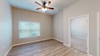 This single-floor residence offers a well-designed, open-concept layout that seamlessly connects the living and kitchen areas. The living space features light wood-look luxury vinyl plank flooring, warm neutral wall tones, and a ceiling fan with integrated lighting, creating a bright and comfortable atmosphere. Large windows fitted with horizontal blinds allow natural light to fill the space while maintaining privacy.

The kitchen is a standout feature, equipped with rich dark espresso cabinetry, granite-look countertops, and a full suite of black appliances including a range, microwave, and refrigerator. A peninsula with a built-in sink and additional counter space adds functionality and enhances the open flow between the kitchen and living area.

The bedrooms are carpeted for comfort and each includes a ceiling fan, a window for natural light, and closet access. The layout provides a sense of spaciousness with generous wall space and clean lines throughout.

The bathroom is finished with the same light wood-look flooring found in the main living areas and includes a shower/tub combination, toilet, and ample space for daily use. Clean white fixtures and neutral walls contribute to a fresh, functional design. Overall, the space presents a cohesive, move-in-ready interior with consistent finishes throughout.