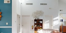 This 550 square foot space in Atlanta, GA, showcases a thoughtful blend of modern design and mid-century aesthetics. The open-concept layout maximizes the compact footprint, creating a sense of spaciousness. Vaulted ceilings add vertical dimension, while large windows flood the interior with natural light, enhancing the airy ambiance.

The living area features a cohesive color scheme with crisp white walls accented by vibrant blue elements. Mid-century modern furniture, including a tufted sofa, wooden coffee table, and sculptural chairs, adds character and functionality. A geometric area rug ties the seating arrangement together, while art pieces and decorative objects provide visual interest.

The bathroom, though compact, is efficiently designed with a pedestal sink, toilet, and a striking blue wainscoting that complements the living area's color palette. A chevron-framed mirror and modern light fixture elevate the space's style.

Wood flooring throughout unifies the space and adds warmth. The property also includes a small office area, seamlessly integrated into the open layout. Stylish pendant lights and recessed lighting contribute to the overall modern aesthetic. This well-designed space demonstrates how thoughtful interior choices can maximize both style and functionality in a limited square footage.