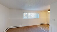 Located at 3335 Austin Bluffs Pkwy in Colorado Springs, CO, this compact one-bedroom, one-bathroom unit offers a practical and well-organized layout across a single floor. The living area features plush carpeting, a textured ceiling, and a wide horizontal window fitted with vertical blinds that allows natural light to fill the space. Baseboard heating runs along the perimeter, ensuring year-round comfort.

The galley-style kitchen is efficiently designed, offering ample white cabinetry on both sides, granite-patterned countertops, a stainless steel sink, and white appliances including an electric range and refrigerator. Light wood-look flooring grounds the kitchen and gives it a clean, bright feel.

The bedroom is a comfortably sized retreat with wall-to-wall carpet, a window for natural light, and access to a dedicated closet. Its neutral white walls provide a versatile backdrop. Adjacent to the bedroom, the bathroom is straightforward and functional, featuring a combined tub and shower, a toilet, and wood-look flooring that ties into the rest of the unit.

A dedicated closet adds convenient storage. The overall aesthetic is clean and neutral, making it a practical living space in the Austin Bluffs neighborhood of Colorado Springs.