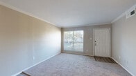 This charming 700 square foot home in Tomball, Texas offers a well-designed living space on a single floor. The property features two bedrooms, including a spacious primary bedroom of 170 square feet, and one full bathroom. The open-concept layout maximizes the use of space, combining the living room and kitchen areas for a seamless flow.

The interior boasts modern finishes throughout, with a neutral color palette that creates a bright and airy ambiance. Large windows in the living area and bedrooms allow for ample natural light, while providing views of the surrounding landscape. The flooring alternates between plush carpeting in the bedrooms and living areas, and sleek laminate in the kitchen and bathroom, adding visual interest and practicality.

The kitchen showcases contemporary navy blue cabinetry, contrasting beautifully with white quartz countertops and a subway tile backsplash. Stainless steel appliances and a modern faucet complete the stylish look. The bathroom features a white vanity with a quartz countertop, complemented by a tiled shower/tub combination.

Storage solutions include built-in shelving and closet space in the bedrooms. Ceiling fans in the living area and bedrooms provide additional comfort. The property's compact size and thoughtful layout make it an ideal option for those seeking an efficient and low-maintenance living space in the Tomball area.