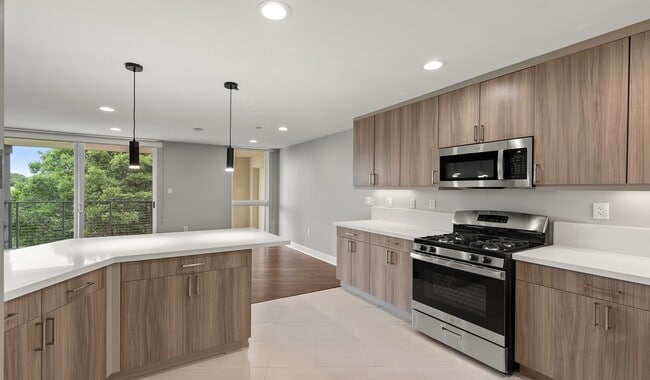 Designer kitchens with quartz countertops, stainless steel appliances and a breakfast bar - Preserve at Marin