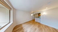 Located at 1011 Pike St in the heart of Seattle, this 2-bedroom, 2-bathroom residence offers a thoughtfully laid-out single-floor plan with a clean, modern aesthetic. Light-toned hardwood flooring runs throughout, creating a warm and cohesive feel across all rooms.

The open living area connects seamlessly to a kitchen featuring warm wood cabinetry, granite countertops, and a breakfast bar peninsula — ideal for casual dining or entertaining. Recessed lighting and wall sconces provide a well-lit, inviting atmosphere.

The generously sized primary bedroom includes mirrored sliding closet doors that enhance the sense of space, with an en-suite bathroom that features a soaking tub set in elegant beige tile surround and chrome fixtures. The second bedroom is bright and airy, with large windows framing lush, verdant tree views, and access to a private balcony — a serene urban retreat. The second bathroom offers tile flooring, a granite vanity, and neutral-toned tile walls.

A dedicated hallway and closet provide additional organization and storage. The consistent use of light walls, natural wood tones, and abundant natural light from large windows lends the entire space a calm, contemporary character well-suited to Seattle urban living.