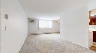 Located at 17833 Whitney Rd in Strongsville, Ohio, this two-bedroom, one-bathroom unit offers a practical and comfortable single-floor layout. The spacious living area is carpeted and filled with natural light through a large window dressed with vertical blinds. A ceiling fan overhead and a wall-mounted air conditioning unit ensure year-round comfort, while baseboard heating runs along the perimeter walls. The open layout connects seamlessly to the kitchen, which features rich dark wood cabinetry, a marble-style countertop, a stainless steel sink, and wood-look flooring — providing a clean contrast to the neutral tones throughout the rest of the unit. A closet with bifold doors is conveniently accessible from the living space. The generously sized primary bedroom includes its own wall A/C unit, a ceiling fan, a large window with vertical blinds, and a wide closet with built-in shelving and a hanging rod. The second bedroom is quieter in scale, with carpeted floors, a window with blinds, and baseboard heating. The bathroom is finished with hexagonal tile flooring, white subway-tiled walls surrounding the tub-shower combo, and a vanity with wood cabinetry.