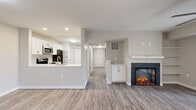 Located at 1212 Chase Heritage Cir in Sterling, Virginia, this single-floor residence offers a thoughtfully designed open-concept layout with a clean, contemporary aesthetic throughout. The main living area features durable wood-look vinyl plank flooring, a striking electric fireplace framed by a white mantel, and a sliding glass door that floods the space with natural light and provides views of the outdoor surroundings, including a nearby playground area. A ceiling fan adds comfort to the living space.

The kitchen is well-appointed with crisp white shaker cabinetry, quartz-style countertops, a decorative tile backsplash, and a full suite of stainless steel appliances including a refrigerator, range, microwave, and dishwasher. A peninsula with a sink connects the kitchen to the main living area, enhancing its open feel.

The bedrooms are carpeted for warmth and comfort, with multiple windows providing ample natural light and ceiling fans for ventilation. The bathroom is finished with a white vanity, marble-look countertop, gold-tone fixtures, and a tub/shower combination. A dedicated in-unit laundry area houses a full-size washer and dryer. Additional flexible space with vinyl plank flooring offers versatility for various uses throughout this well-maintained home.