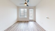 Located at 523 N Spring St in Greensboro, NC, this well-appointed 2-bedroom, 2-bathroom residence offers a thoughtfully designed single-floor layout with modern finishes throughout. The open-concept living area seamlessly connects the kitchen, dining, and living spaces, creating a bright and welcoming atmosphere. Light wood-tone flooring flows through the main living areas, complemented by neutral walls and abundant natural light from multiple windows. A ceiling fan adds a practical touch to the living room, which opens to a private balcony. The kitchen is a standout feature, centered around a large island with a white quartz countertop, an undermount stainless steel sink, and stylish pendant lighting. White shaker cabinetry, a subway tile backsplash, and a full suite of stainless steel appliances — including a refrigerator, range, microwave, and dishwasher — complete the space. Both bathrooms are finished with white vanities, quartz countertops, wood-look tile flooring, and glass-enclosed walk-in showers featuring marble-style tile surrounds. The bedrooms offer a calm retreat; the primary bedroom includes direct balcony access, while both rooms are carpeted for comfort. Four closets, a dedicated laundry area, and ample storage round out this functional and stylish home.