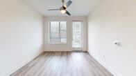 Located at 523 N Spring St in Greensboro, NC, this well-appointed 2-bedroom, 2-bathroom residence offers a thoughtfully designed single-floor layout with modern finishes throughout. The open-concept living area seamlessly connects the kitchen, dining, and living spaces, creating a bright and welcoming atmosphere. Light wood-tone flooring flows through the main living areas, complemented by neutral walls and abundant natural light from multiple windows. A ceiling fan adds a practical touch to the living room, which opens to a private balcony. The kitchen is a standout feature, centered around a large island with a white quartz countertop, an undermount stainless steel sink, and stylish pendant lighting. White shaker cabinetry, a subway tile backsplash, and a full suite of stainless steel appliances — including a refrigerator, range, microwave, and dishwasher — complete the space. Both bathrooms are finished with white vanities, quartz countertops, wood-look tile flooring, and glass-enclosed walk-in showers featuring marble-style tile surrounds. The bedrooms offer a calm retreat; the primary bedroom includes direct balcony access, while both rooms are carpeted for comfort. Four closets, a dedicated laundry area, and ample storage round out this functional and stylish home.