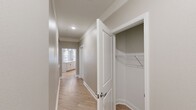 This 1,130-square-foot apartment at 2701 Watermark Boulevard features 2 bedrooms, 2 bathrooms, and a well-planned single-floor layout. The open-concept kitchen and living area serves as the heart of the unit, showcasing light wood-tone flooring, a large central island with a built-in sink, pendant lighting with brass accents, and a full suite of stainless steel appliances including a refrigerator, electric range, and over-the-range microwave. Light-toned cabinetry with a white tile backsplash and quartz-style countertops complete the kitchen's clean, modern aesthetic. Both bedrooms feature ceiling fans with light fixtures, large windows with natural light, and neutral wall tones. The primary bedroom spans 160 square feet. The primary bathroom offers a dual-sink vanity with wood-finish cabinetry and brushed nickel hardware, while the second bathroom includes a single vanity and a tiled shower-tub combination. Light wood-look flooring extends consistently throughout the unit. Additional spaces include two closets, three hallways, and a dedicated laundry room equipped with a washer and dryer, plus a window overlooking the exterior.