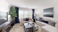 Located at 2113 Bromley Park Dr in Winston-Salem, NC, this single-floor residence offers a well-designed layout with a comfortable and cohesive living environment. The spacious living room is a standout feature, bathed in natural light through large windows dressed with navy curtains that frame views of lush greenery outside. Plush carpeting and an open feel make this area ideal for relaxing or entertaining. A tiled entryway transitions smoothly into the carpeted living space, providing both practicality and style. The kitchen is efficiently laid out with ample white cabinetry extending to the ceiling, white appliances including a range and refrigerator, light countertops, and tile flooring, all illuminated by track lighting overhead. Multiple bedrooms offer comfortable retreats, each carpeted and featuring closet storage. The bedrooms are bright and well-proportioned, with windows allowing in natural light. The bathrooms are finished with tile flooring and include a tub-shower combination. A dedicated in-unit laundry area with a full-size washer and dryer adds notable convenience. Throughout, the residence maintains a clean, neutral color palette that creates a calm and inviting atmosphere.
