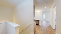 Located at 5104 Cherry Hill Rd in Cohoes, NY, this single-floor, 2-bedroom, 2-bathroom home offers a thoughtfully designed layout with contemporary finishes throughout. The interior is characterized by light-toned hardwood-style flooring that runs through the main living areas, creating a clean and cohesive aesthetic.

The kitchen is a standout feature, equipped with warm wood cabinetry, granite countertops, a subway tile backsplash, and stainless steel appliances including a refrigerator and dishwasher. A pendant light adds a refined touch, and the space flows naturally into the dining area, which is accented by a chandelier overhead. The living room benefits from vaulted ceilings and large sliding glass doors that invite natural light and provide outdoor views.

Both bedrooms are carpeted for comfort, with one featuring a large window with outdoor views and the other offering closet access. The bathrooms are finished with white cabinetry, granite-topped vanities, and hardwood-style flooring. A dedicated laundry room houses a full-size washer and dryer with overhead wire shelving. The overall ambiance is bright, clean, and move-in ready.