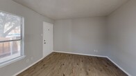 Located at 1839 S Glenbrook Dr in Garland, TX, this two-story home offers a practical and comfortable layout spread across two floors. The main level features a welcoming living room with light luxury vinyl plank flooring, a textured ceiling, and a ceiling fan, opening into a combined dining and kitchen area. The kitchen is equipped with sleek gray shaker-style cabinets, light countertops, a stainless steel sink with a matte black faucet, and black appliances including a refrigerator and range. The lower level also includes a full bathroom with white tile surround and a tub-shower combo.

Upstairs, the spacious primary bedroom includes a ceiling fan, dedicated closet space, and access to additional rooms. The second bedroom features natural light through multiple windows fitted with blinds and its own ceiling fan. Both upper bedrooms continue the light LVP flooring found throughout the home. Three bathrooms in total serve the household, providing excellent convenience. With five closets distributed across the home, storage is plentiful. Neutral gray walls, clean white trim, and consistent flooring create a cohesive, move-in-ready aesthetic throughout this well-organized two-story home.