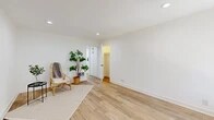 Located at 2301 W La Habra Blvd in La Habra, CA, this single-story, one-bedroom, one-bathroom unit offers a clean, modern aesthetic throughout its thoughtfully arranged floor plan. Light wood-look flooring flows seamlessly across every room, complemented by crisp white walls and bright recessed lighting that lend an airy, cohesive feel to the space.

The living room is generously proportioned, featuring a ceiling fan with lighting and a large window dressed with vertical blinds, inviting natural light and outdoor views. Adjacent to the living area, the dining space accommodates a full dining table and benefits from its own window overlooking greenery outside.

The galley-style kitchen is a standout feature, outfitted with white shaker cabinetry, matte black hardware, white quartz countertops, a classic subway tile backsplash, stainless steel appliances, and a deep single-basin sink — combining style with practical functionality.

The spacious primary bedroom includes recessed lighting, a wall heater, and access to a dedicated walk-in closet. The bathroom is clean and contemporary, featuring a full tub-shower combo, a white vanity with ample drawer storage and matte black hardware, and a window for natural ventilation. A connecting hallway ties all rooms together efficiently, completing this well-designed unit.