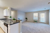 Located at 13671 Cridercrest Pl in Woodbridge, VA, this single-floor, 1-bedroom, 2-bathroom residence offers a well-planned layout designed for comfortable everyday living. The galley-style kitchen is outfitted with white cabinetry, dark granite-style countertops, a full suite of white appliances including a dishwasher, and tile flooring. A breakfast peninsula opens the kitchen toward the dining and living areas, creating a natural flow throughout the common spaces. The living room is generously proportioned, featuring neutral carpet, soft natural light from large windows, and direct access to a private patio. The spacious primary bedroom features plush carpeting, a large window with outdoor views, and a double-door closet providing ample storage. Two bathrooms serve the residence, including one with a white vanity, granite-style countertop, and a large mirror. Additional highlights include a dedicated in-unit laundry room with full-size washer and dryer hookups, a utility room, and multiple closets throughout. Neutral tones, consistent finishes, and a practical layout make this a functional and inviting home in a convenient Northern Virginia location.
